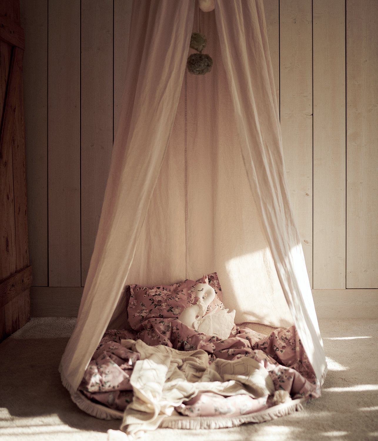 Beige reading tent with pom poms